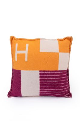 un coussin orange et blanc orné d'un motif violet et blanc