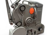 un vieux projecteur de cinéma posé sur une surface blanche
