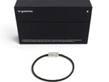 un bracelet noir avec un fermoir en argent et un coffret noir