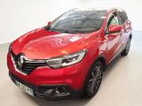 Une voiture rouge est garée dans une pièce blanche