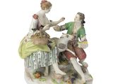 une figurine représentant un homme et une femme en train de nourrir un mouton