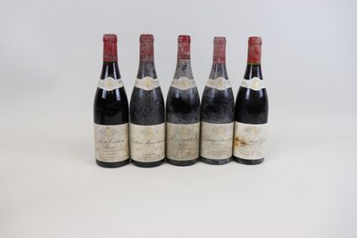 quatre bouteilles de vin sont alignées sur une surface blanche