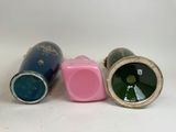 three different colored vases sitting next to each other on a white surface