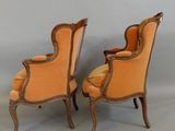 pair of orange upholstered chairs with gold trim