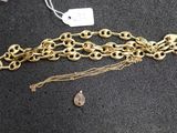 a close up of a gold chain bracelet with a tear charm