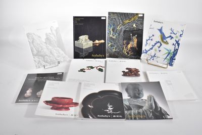 le contenu d'une collection de livres est disposé sur une surface blanche