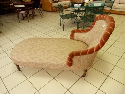 une chaise longue dans un salon avec une table et des chaises