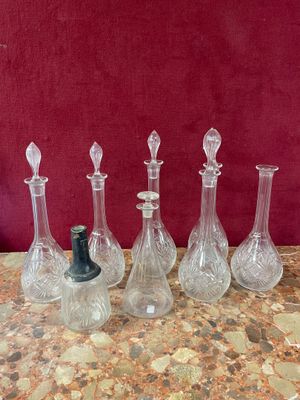 four glass vases sitting on a table with a red background