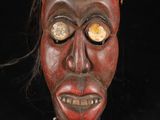 une image d'un masque en bois sur fond noir