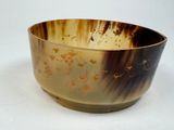 a brown and black bowl sitting on a white surface