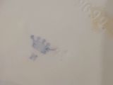 a white plate with a blue flower on it