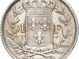 a close up of a silver coin with a crown on top of it