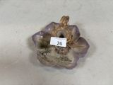 une figurine représentant une fleur, à laquelle est accrochée une étiquette