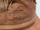 a close up of a clay sculpture of a flower on a pedestal
