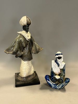 deux figurines représentant une femme et un homme assis par terre