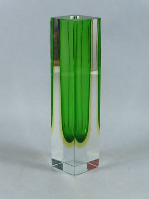 a green vase that is sitting on a white surface