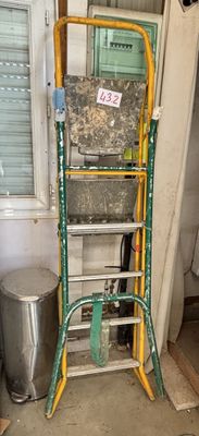 une échelle qui se trouve à côté d'une poubelle dans une pièce