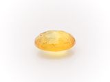 a yellow sapphire stone on a white background