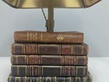 books stacked on top of each other with a lamp on top of them