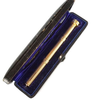 un stylo dans un étui ouvert, posé sur une surface blanche