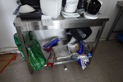 une table en métal sur laquelle sont posés tout un tas d'assiettes et de tasses