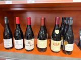 plusieurs bouteilles de vin sont alignées sur une étagère dans un magasin