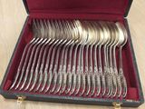 silverware in a case on a wooden table with a red cloth