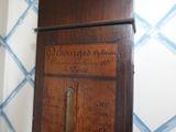 a wooden grandfather clock with writing on it in a room
