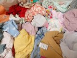 a pile of clothes that is sitting on a bed