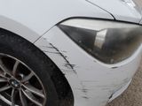 a close up of a white car with scratches on the side of it