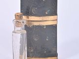 a small glass bottle with a wooden stick next to it