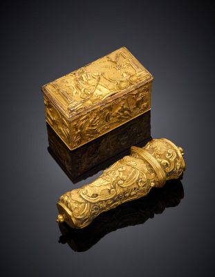 a gold snuff and a box on a black surface
