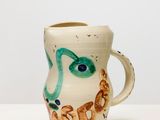 une image représentant une tasse en céramique sur laquelle est peint un serpent