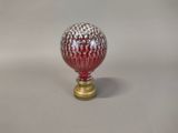 a red and white glass ball on a gold stand