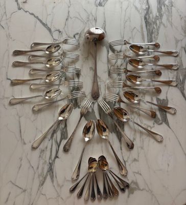 a lot of silver spoons and forks arranged in the shape of a bird