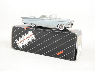 une petite voiture posée sur une boîte, sur une surface blanche