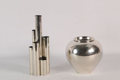 a silver vase next to a silver vase on a white surface