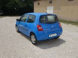 a small blue car parked in front of a building