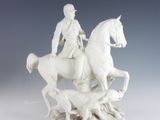 a statue of a man riding on a horse with a dog