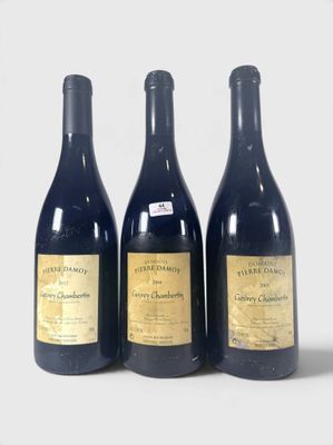 trois bouteilles de vin sont alignées sur une surface blanche