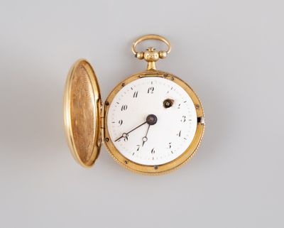 a gold pocket watch sitting on a white surface