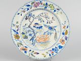 a blue and white plate with a bird and flowers on it