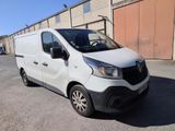 La camionnette blanche est garée sur le parking près d'un immeuble.