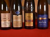 several bottles of wine are lined up on a red cloth
