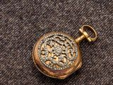 un gros plan d'une montre de poche en or sertie de diamants