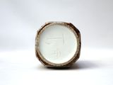 a close up of a white vase on a white surface