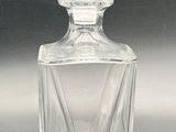 clear glass bottle with a diamond shaped top sitting on a table