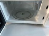a white microwave with the door open on a white counter