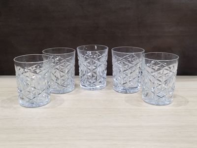 lot de quatre verres en cristal posés sur une table en bois