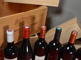 several bottles of wine are lined up in a row next to a wooden box
